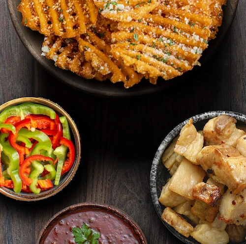 Papas Waffle Cheddar con tocino crujiente y jalapeño BBQ